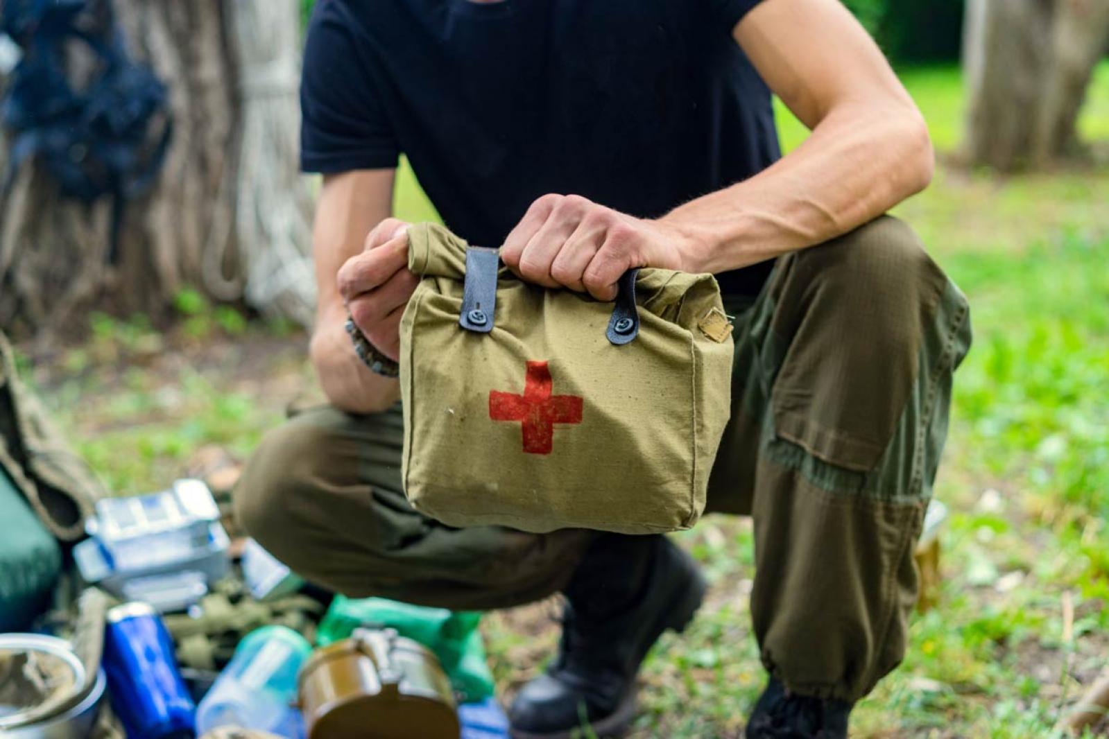 Man holding a first aid kit in the woods