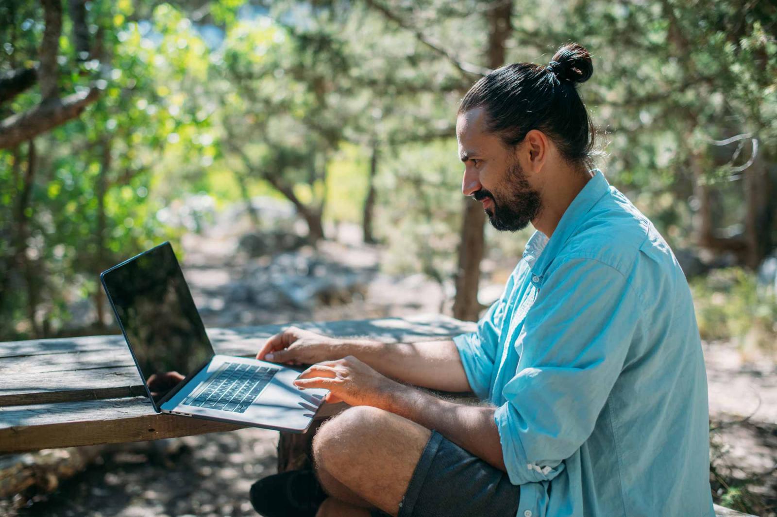 Man sitting outside using a laptop