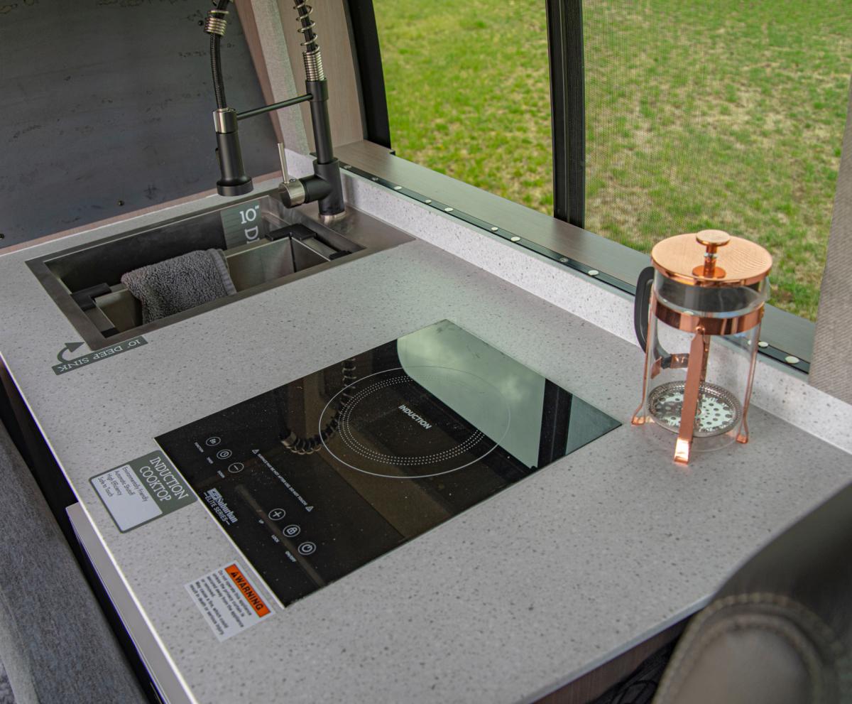 The desk, sink and cooktop setup inside an Antero Adventure Van
