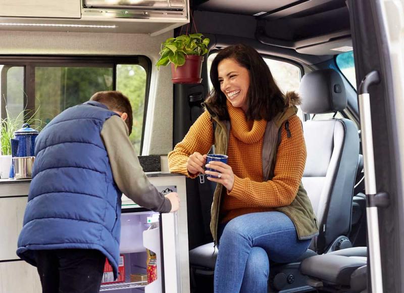 A mom and her son hanging out in an Antero Adventure Van with refrigerater in background