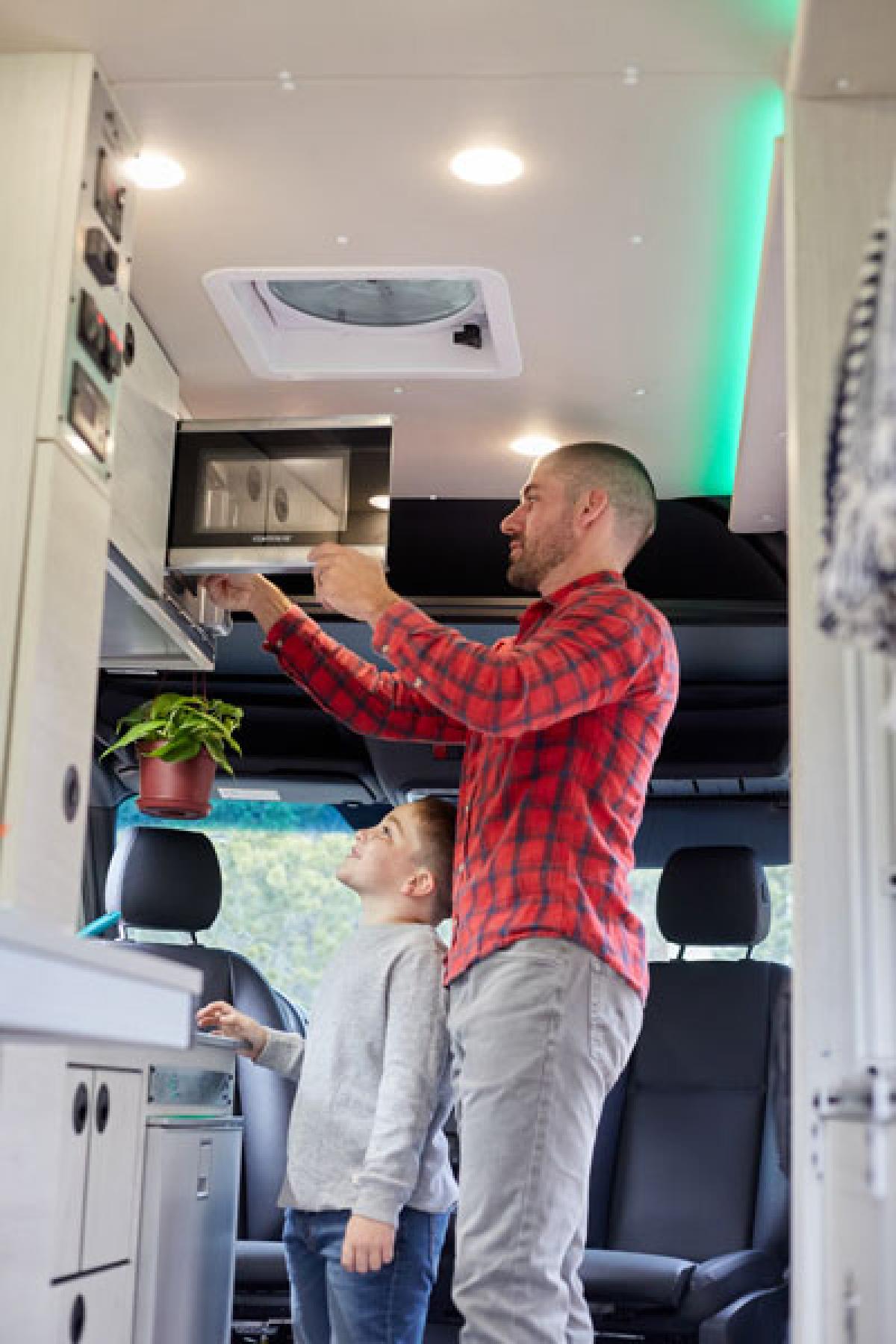 A man using the microwave inside an Antero Adventure Van