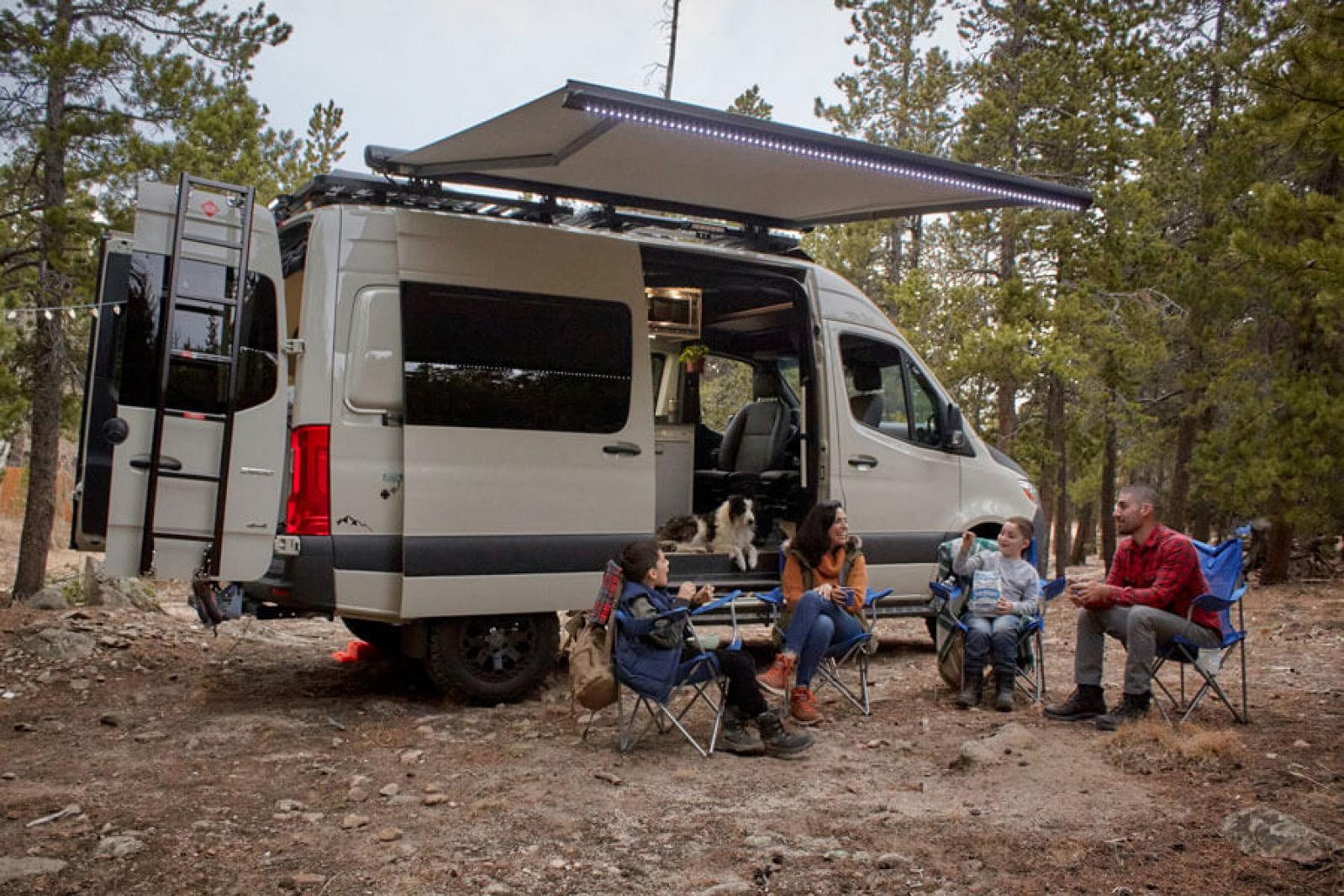 A family outdoors sitting in chairs in front of an Antero Adventure Van