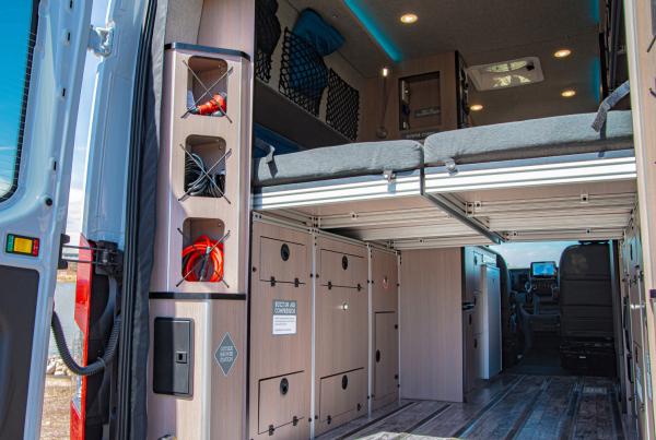 The open back doors of an Antero Adventure Van showing the murphy bed functionality.