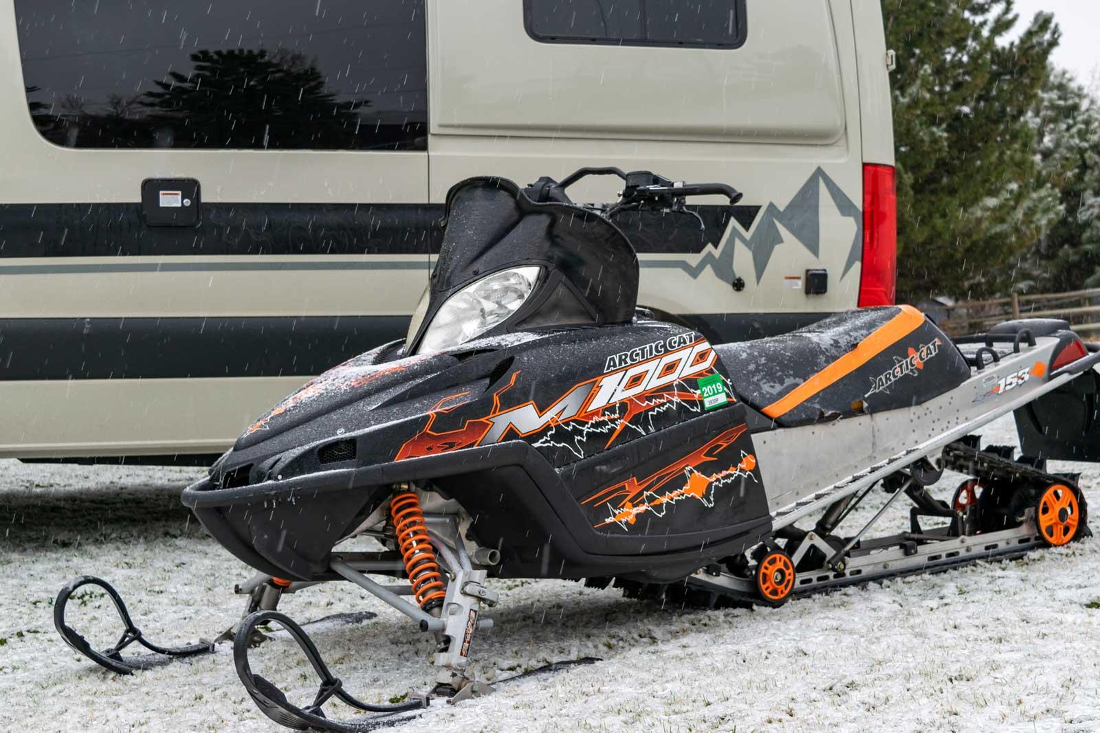 A snowmobile in front of an Antero Adventure Van