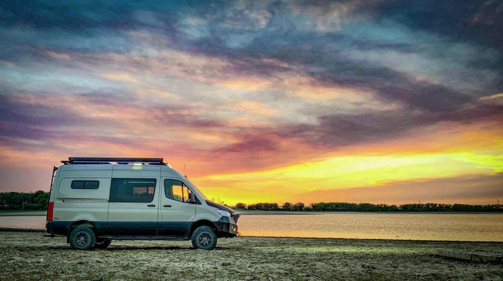 An Antero Adventure Van next to a lake with a sunset in the background