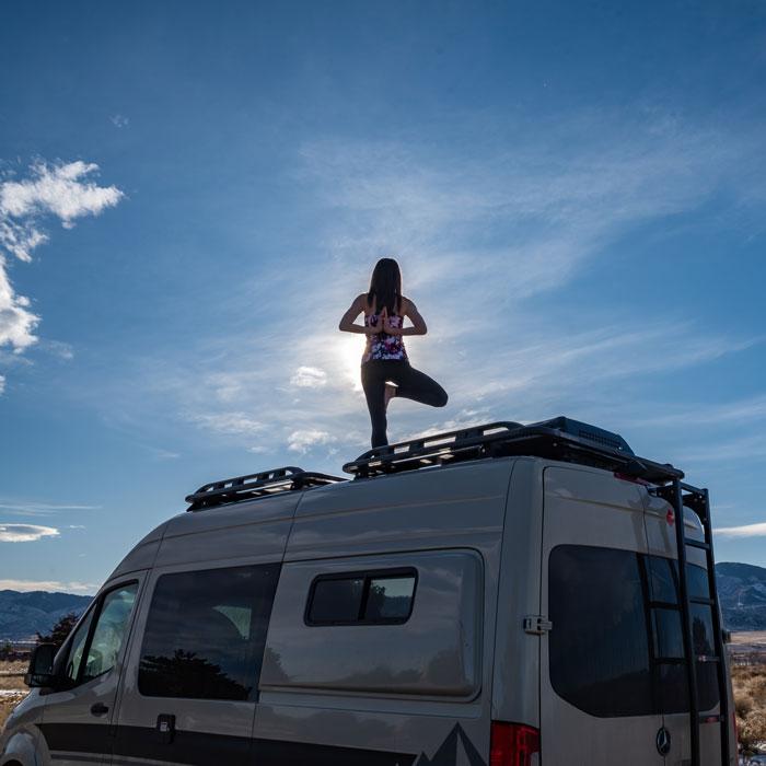 A person doing yoga on the top of an Antero Adventure Van
