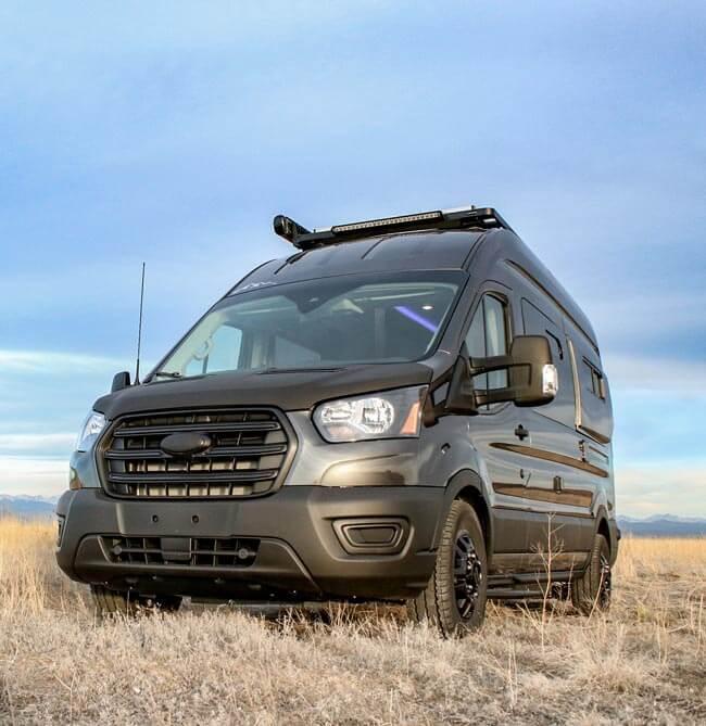 A Pikes Peak Antero Adventure Van in a field from a front angle