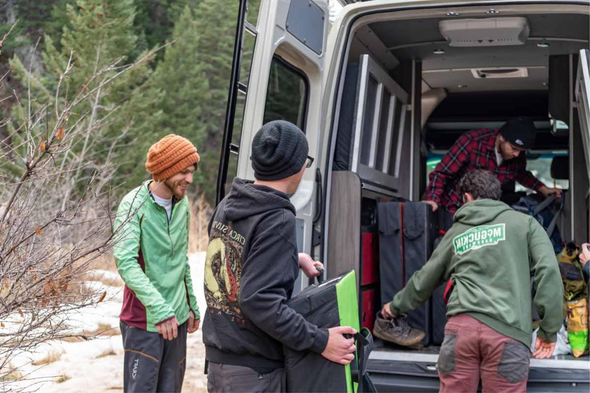 A group of climbers removing boulder crash pads from the back of an Antero Adventure Van